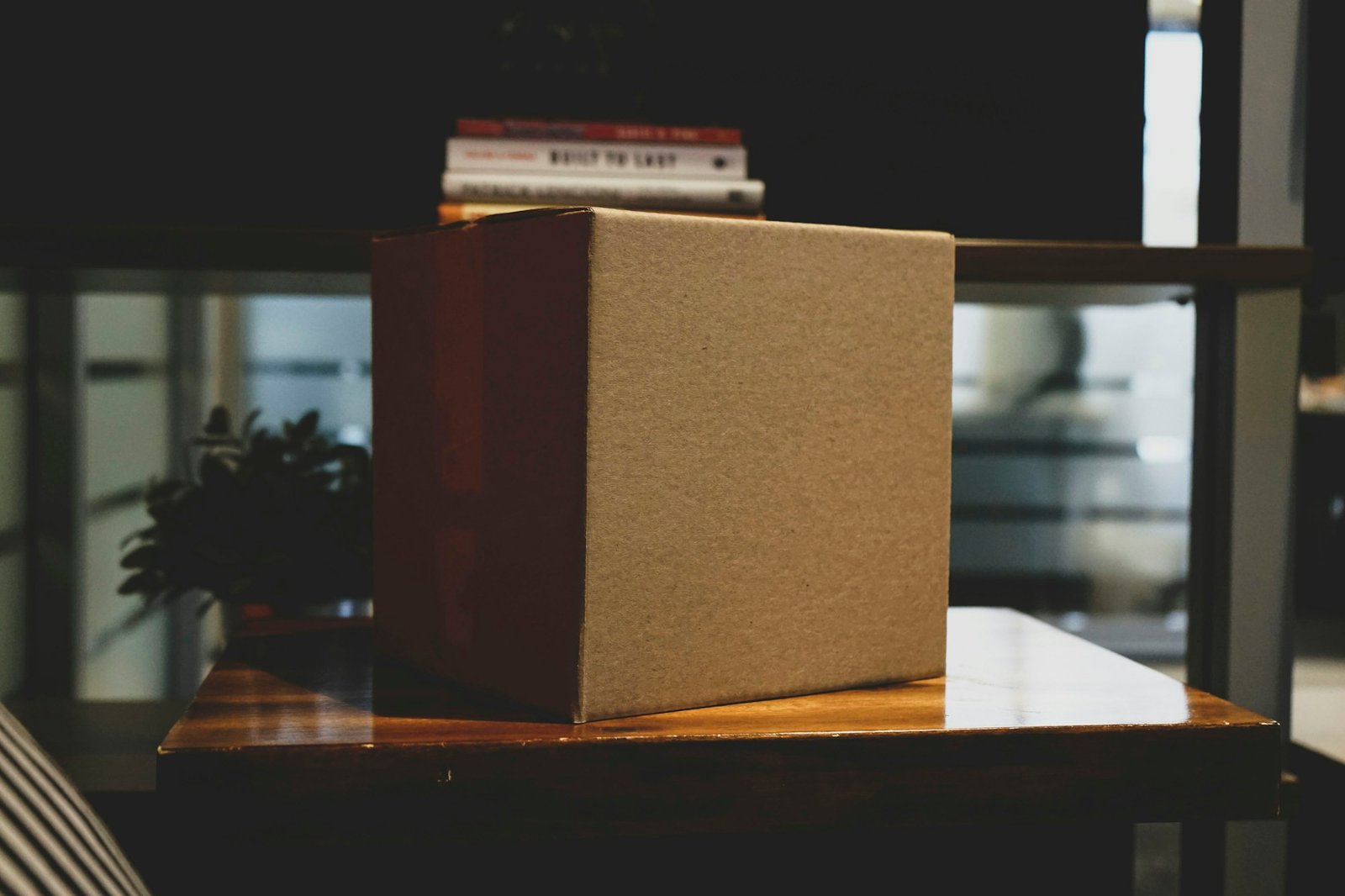 A plain cardboard shipping box on a wooden surface