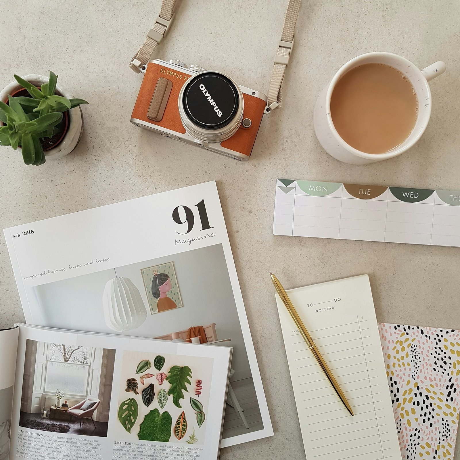 Camera, notebooks and creative materials on a table