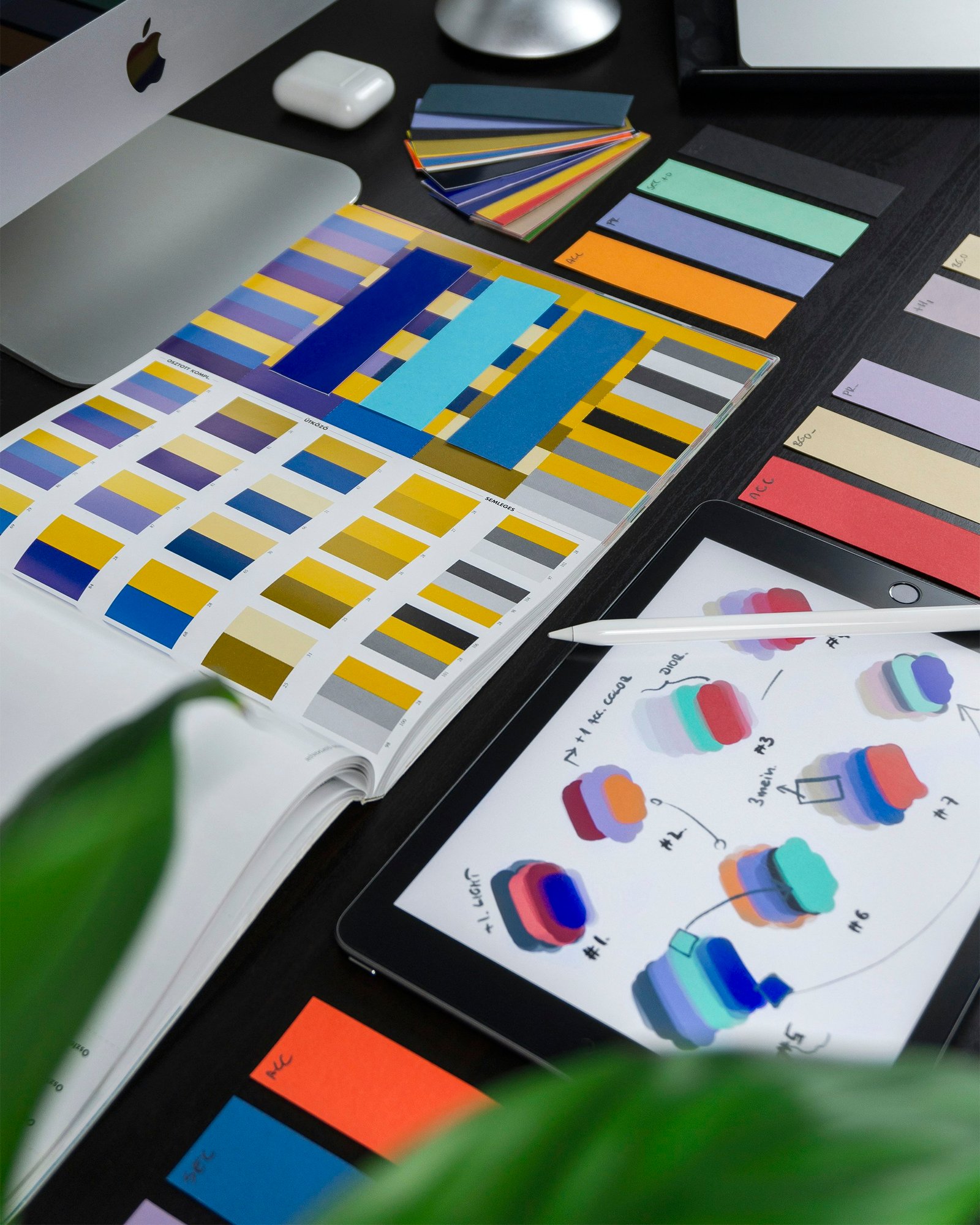 Colour swatches and digital design tools arranged on a desk
